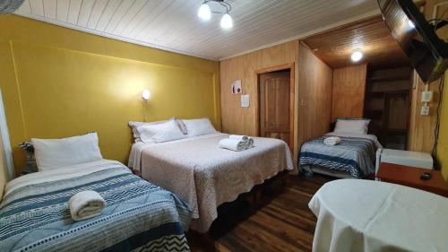 a room with two beds with towels on them at Hostal Las Heras in Temuco