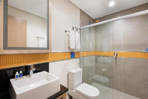 a bathroom with a toilet and a sink and a shower at TRYP BY WYNDHAM São Paulo Airport - Hotel de Transito Terminal 3 -Lado Ar - Área restrita á passageiros já embarcados - Piso 1 in Guarulhos