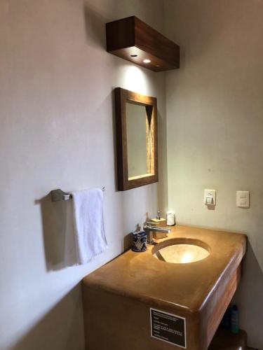 a bathroom with a wooden sink and a mirror at Las Villas, Villa Alegria,Troncones in Troncones