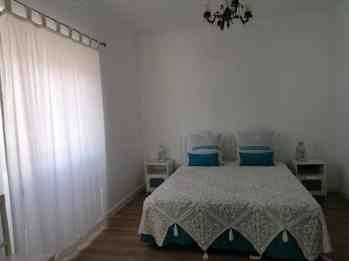 a bedroom with a bed with blue pillows at Alojamento Justo - vila de Montargil in Montargil