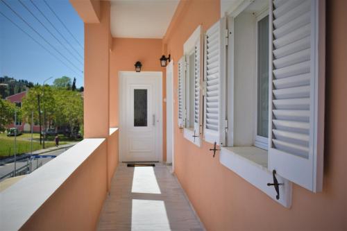 a hallway of a house with windows and a white door at Christina's apartment in Kontokali