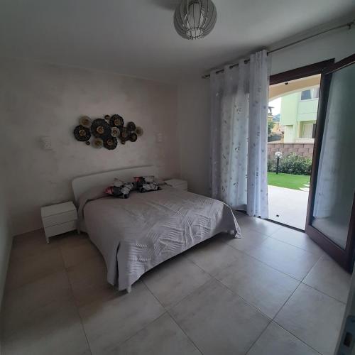 a bedroom with a bed and a large window at Casa di Matteo in Villasimius