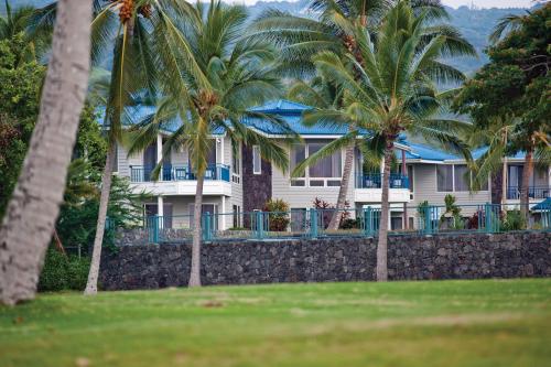 a house with palm trees in front of it at Wyndham Mauna Loa Village in Kailua-Kona