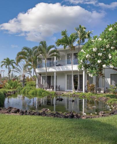a house with a pond in front of it at Wyndham Mauna Loa Village in Kailua-Kona