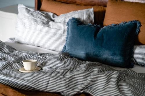 a coffee cup sitting on top of a bed with pillows at Maleny Lodge in Maleny