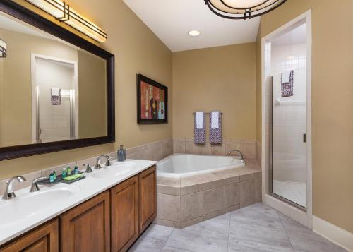 a bathroom with two sinks and a tub and a shower at Club Wyndham Nashville in Nashville