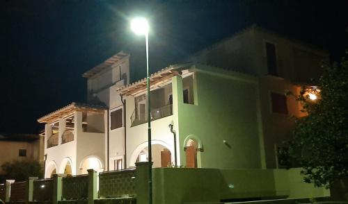 a white building with a street light in front of it at Casa di Matteo in Villasimius