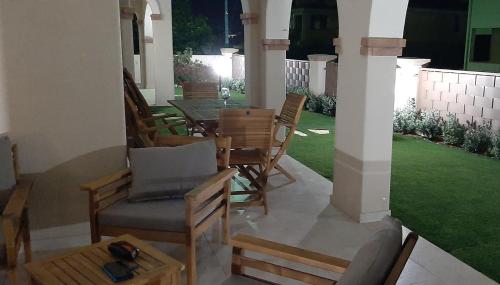 a patio with chairs and a table and a lawn at Casa di Matteo in Villasimius