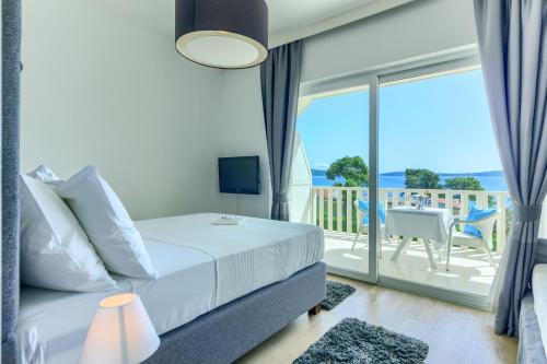 a bedroom with a bed and a view of the ocean at Hotel Riva Kaštela with swimming pool in Kaštela