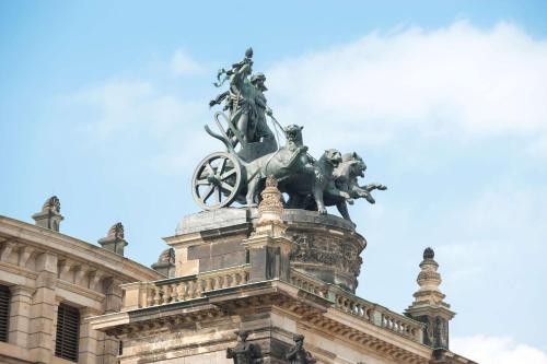 a statue on the top of a building at Dorint Hotel Dresden in Dresden