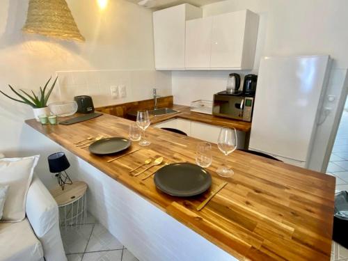 a kitchen with a wooden counter with plates and wine glasses at La Cascade verte /Appartement /jardin /parking in Braux