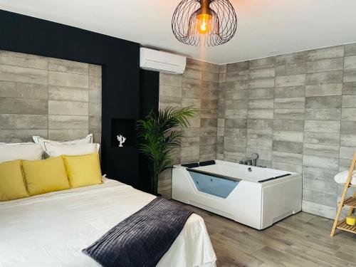una camera da letto con un letto grande e una vasca da bagno di Superbe appartement avec balnéo. a Saint-Cyprien