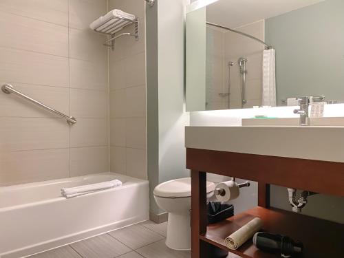 a bathroom with a toilet and a sink and a tub at Hyatt Place San Jose Pinares in San José