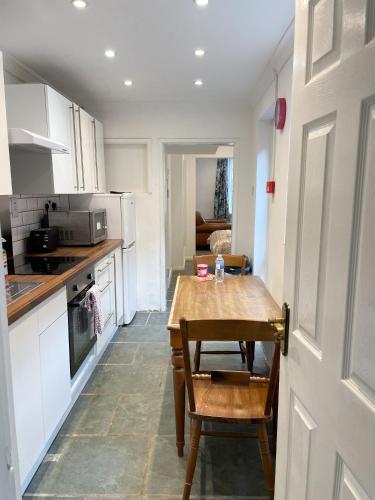 a small kitchen with a wooden table in a room at 147 knapp road house in London