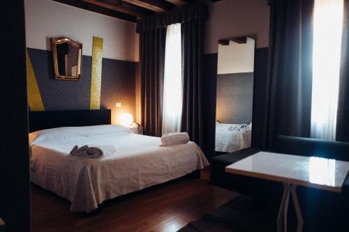 a bedroom with two beds and a table and window at Ristolocanda Grani Di Pepe in Flaibano