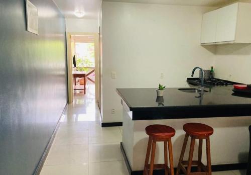 a kitchen with two bar stools and a counter at CUMBUCO - Eco Paradise - AP 112 in Caucaia