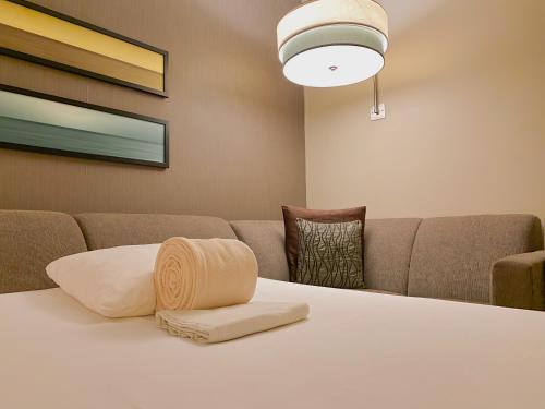 a room with a couch and a table with a pillow at Hyatt Place San Jose Pinares in San José