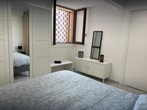 Habitación blanca con cama y ventana en Monaco quartier Monte Carlo magnifique 2 pièces en Montecarlo