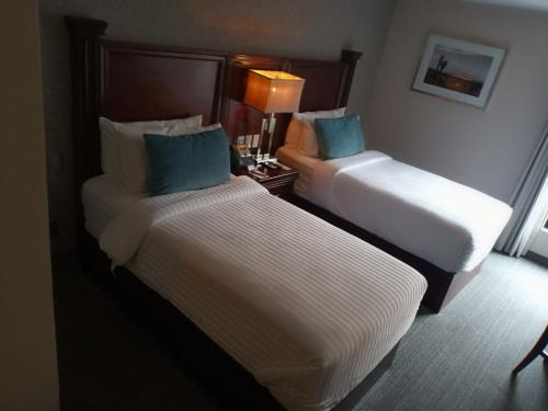 a hotel room with two beds and a table at Gran Hotel Concordia San Luis Potosi in San Luis Potosí