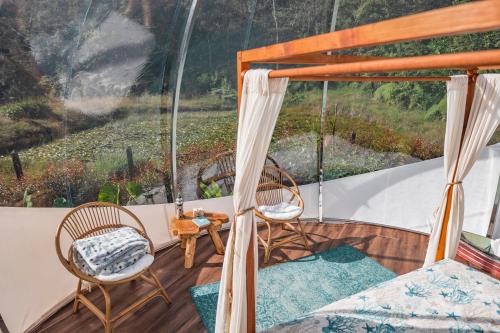 - une véranda avec 2 chaises et une table dans l'établissement BubbleSky Glamping 15 min from Medellin, à Rionegro