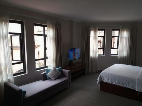 a bedroom with a bed and a couch and windows at Gran Hotel Concordia San Luis Potosi in San Luis Potosí