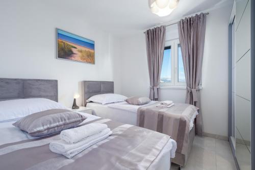 1 dormitorio con 2 camas y ventana en Sea Vista Apartments Kastela, en Kaštela