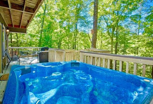 a hot tub on the back porch of a house at Happy Trails, Hot Tub, In Pigeon Forge Near Strip, Hot Tub, WIFI!!! in Pigeon Forge