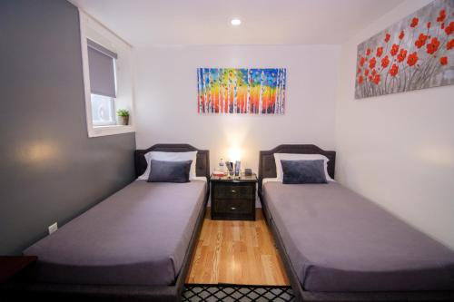 2 Betten in einem Zimmer mit Wandgemälde in der Unterkunft Elegant 2 Bedroom Suite w Modern Amenities in Brooklyn