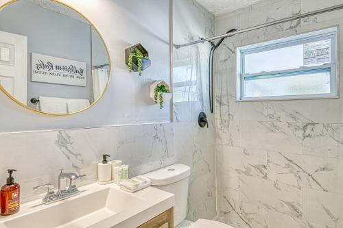 Un baño blanco con lavabo y espejo. en Deerfield Delight, en Deerfield Beach