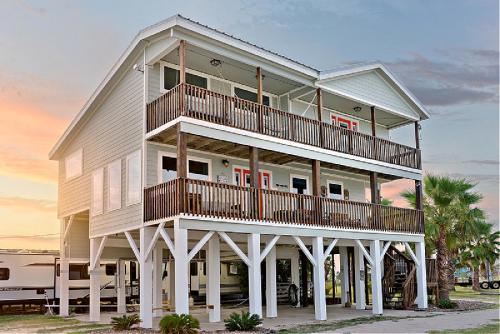 ポートラバカにあるBay Front Home with Spectacular Sunrise Viewsの広い白い家(ビーチにバルコニー付)