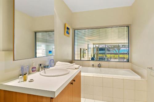 a bathroom with a sink and a tub and a window at Apartment 20 Kalimna in Lorne
