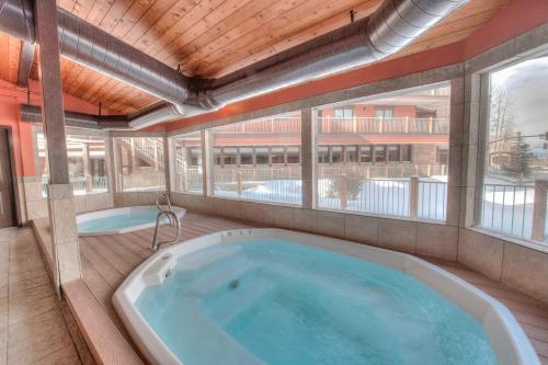 Cette chambre dispose d'une grande baignoire et d'une grande fenêtre. dans l'établissement Breckenridge Ski Hideaway, à Breckenridge