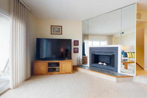 a living room with a fireplace and a large television at Seaside Villas --- 40123 Seaside Drive in Fenwick Island