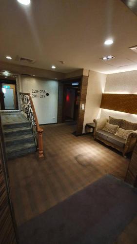 a lobby with a couch and a staircase in a building at Chia Shih Pao Hotel in Taibao