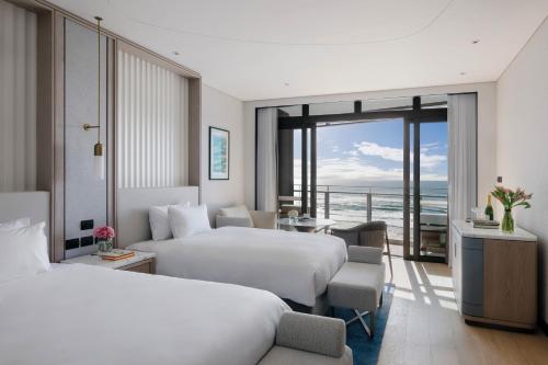 a hotel room with two beds and a view of the ocean at The Langham, Gold Coast and Jewel Residences in Gold Coast