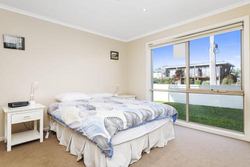 a bedroom with a bed and a large window at The Dunes 1 in Apollo Bay