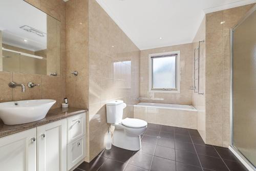 a bathroom with a toilet and a sink and a tub at The Dunes 1 in Apollo Bay