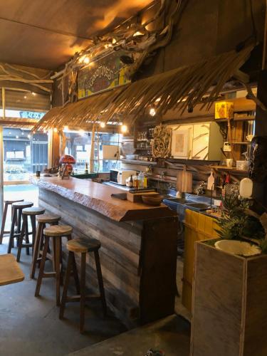 a large kitchen with a bar with stools in it at 下田市旧南豆 in Shimoda