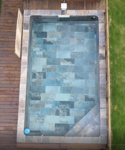 a swimming pool sitting on top of a wooden deck at Mara'ai le spot Tubuai, Chambre Triple Deluxe Mahu SDB Privée avec piscine in Tubuai