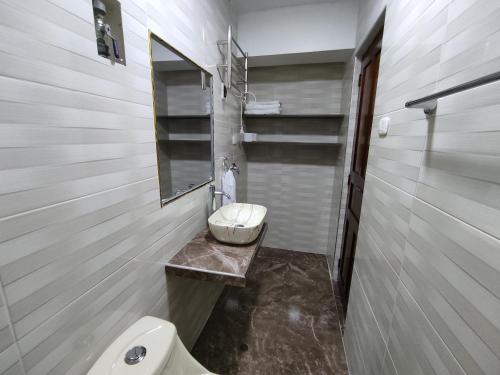 a bathroom with a toilet and a sink and a mirror at MINI DEPARTAMENTO LAS VEGAS in Chimbote