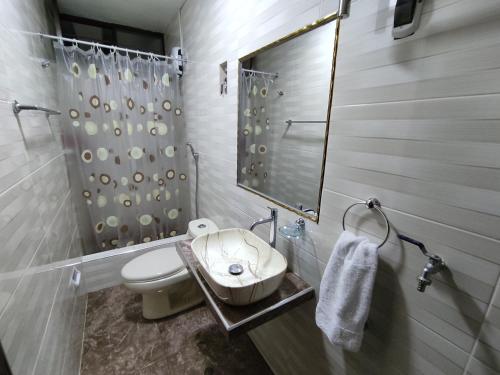y baño con aseo, lavabo y espejo. en MINI DEPARTAMENTO LAS VEGAS en Chimbote