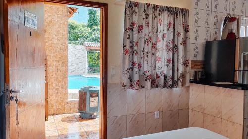 a bathroom with a window with a view of a pool at Solar Maresias Flats in Maresias
