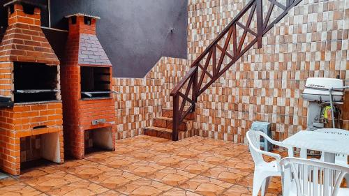 an outdoor patio with a brick oven and a table at Solar Maresias Flats in Maresias