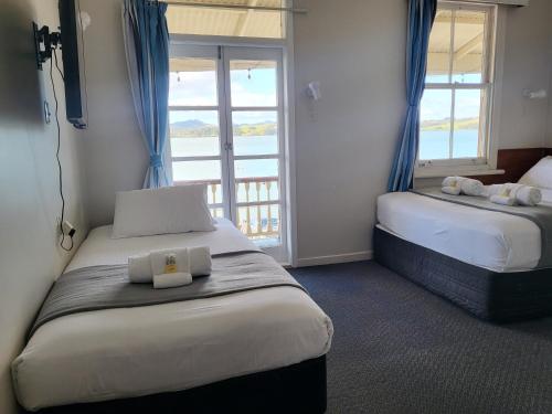 a hotel room with two beds and a window at Mangonui Hotel in Mangonui