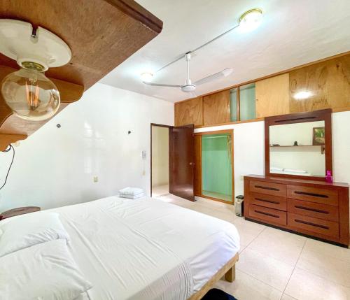 a bedroom with a large white bed and a dresser at BELLAVISTA HOUSE /Increíble sala in Campeche
