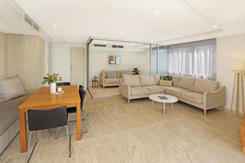 a living room filled with furniture and a table at Breeze Mooloolaba, Ascend Hotel Collection in Mooloolaba