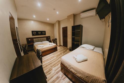 Cette chambre comprend deux lits et un bureau. dans l'établissement Shushupe Hotel, à Tingo María