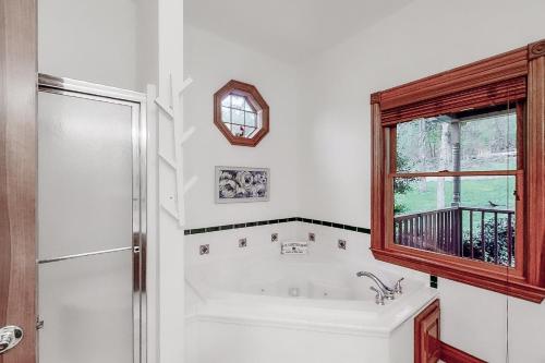 a white bathroom with a tub and a window at Heartland House in New Tazewell