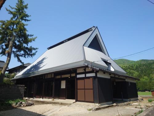a building with a white roof and a window at TOKI NO YADO in Nakanogō