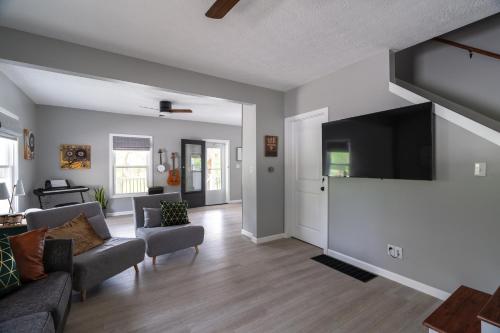 a living room with a couch and a flat screen tv at SAND HILL COTTAGE 3 Bedroom Home near PURDUE! River & Park View in West Lafayette